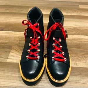 Black combat boots with red laces and buckle